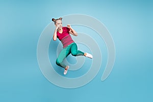 Full length body size photo of focused concentrated girl readying to fight empty space nearby wearing green pants