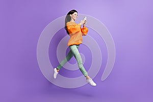 Full length body size photo of jumping ballerina using cellphone in casual clothes isolated on vivid purple color