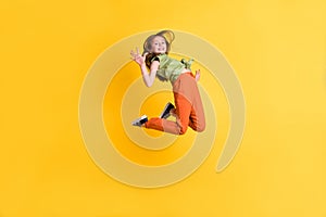 Full length body size photo little girl jumping up careless waving hand isolated vibrant yellow color background