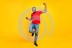 Full length body size photo of rejoicing glad cheerful happy black man dancing with joy while isolated with yellow