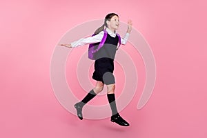 Full length body size photo schoolgirl jumping running on lesson waving hand isolated pastel pink color background