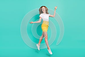 Full length body size photo smiling schoolgirl jumping up happy graceful isolated vivid teal color background