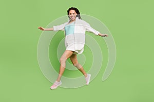 Full length body size photo woman jumping running laughing isolated pastel green color background