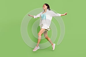 Full length body size photo woman jumping running smiling isolated pastel green color background