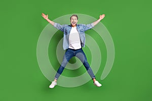 Full length body size photo of young guy jumping up careless playful isolated bright green color background