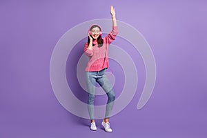 Full length body size photo of young woman dancing wearing headphones smiling closed eyes isolated on bright violet