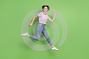 Full length body size profile side view of pretty cheerful girl jumping running waving hi isolated over green pastel