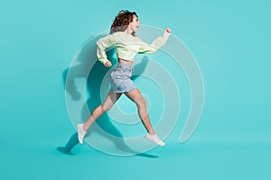 Full length body size side profile photo of beautiful girl jumping high hurrying up isolated on vibrant teal color