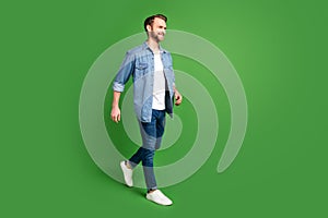 Full length body size side profile photo of confident man wearing stylish clothes smiling isolated bright green color