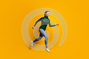 Full length body size side profile photo laughing girl jumping high running fast isolated on vibrant yellow color