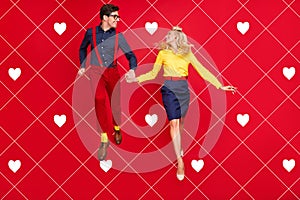 Full length body size view of attractive cheerful carefree couple jumping dancing rest isolated over bright red color photo