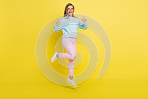 Full length body size view of attractive cheerful girl jumping showing thumbup ad isolated over bright yellow color