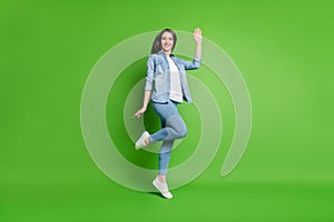 Full length body size view of attractive cheerful girl jumping waving hi isolated over bright green color background
