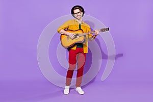 Full length body size view of attractive cheerful guy playing guitar solo isolated over bright violet purple color