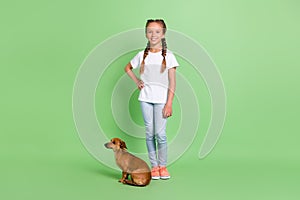 Full length body size view of attractive cheerful preteen girl walking cute doggy isolated over green color background