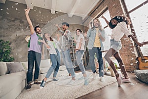 Full length body size view of attractive cool funky cheerful best friends dancing having fun celebrating in house loft