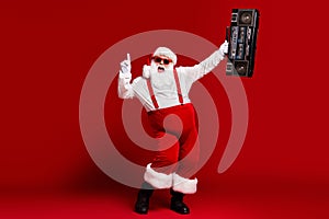 Full length body size view of his he attractive cheerful Santa having fun dancing carrying retro cassette tape player