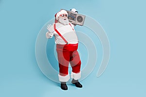 Full length body size view of his he nice bearded cheerful cheery positive glad Santa carrying tape cassette player