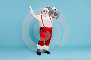 Full length body size view of his he nice cool bearded cheerful cheery Santa carrying vintage cassette player dancing