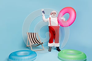 Full length body size view of his he nice glad cheerful fat bearded Santa traveler holding in hands pink circle docs