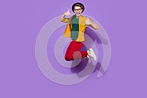 Full length body size view of nice cheerful guy jumping showing thumbup isolated over bright violet purple color