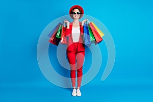 Full length body size view of nice fashionable cheerful lady wearing casual clothing carrying buyings isolated on bright photo