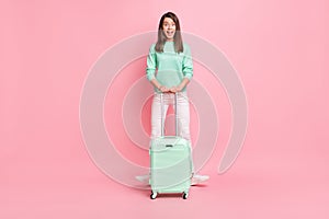 Full length body size view of pretty cheerful girlish girl traveler having fun with valise isolated on pink pastel color