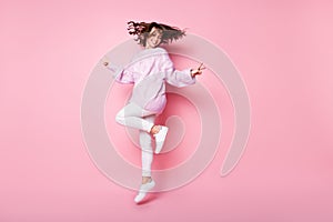 Full length body size view of pretty cheerful wavy-haired girl jumping showing v-sign isolated on pink pastel color