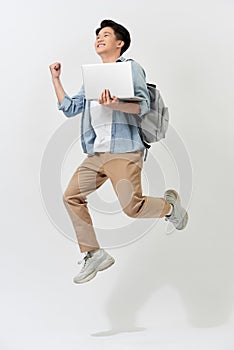 Full length body size of young Asian student man jumping in air using laptop with backapck isolated over white color background