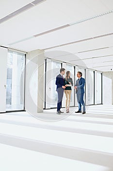 Full length of business people having discussion in empty office