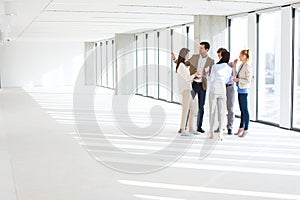 Full length of business people having discussion in empty office space