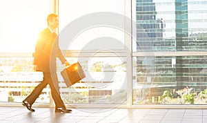 Full length of businessman with briefcase walking in office building