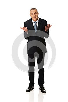 Full length businessman making undecided gesture