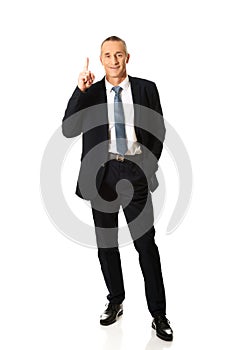 Full length businessman pointing upwards