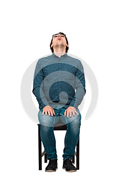 Full length businessman, seated on a chair, looking up astonished, isolated on white background. Surprised business worker, open