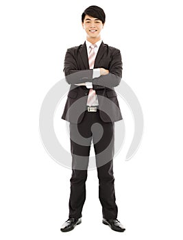 Full length of businessman standing and across arms