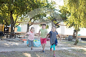 Full length of children holding hands and running at park