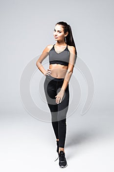 Full length of confident beautiful fitness woman standing over white background