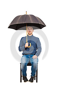 Full length of confident businessman seated on chair standing under his open umbrella looking to camera isolated on white