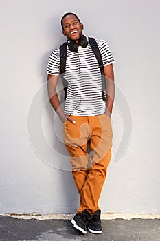 Full length cool young african american man standing against gray wall