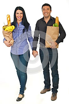 Full length of couple carrying bags with food