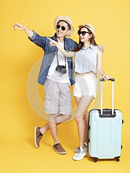 Full length of  Couple with travel luggage and camera looking something