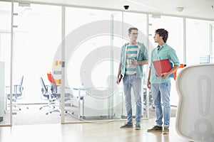 Full-length of creative businessmen conversing at office