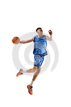 Full-length dynamic image of young man, basketball player practicing, playing isolated over white background. Sport