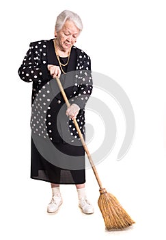 Full length of elderly woman cleaning house with broom