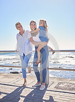 Full length of female family members posing together at the beach on a sunny day. Grandmother, mother and granddaughter