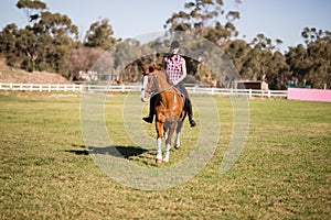 Full length of female jockey horseback riding