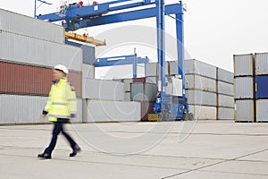 Full-length of female worker walking in shipping yard