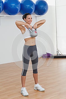 Full length of a fit woman exercising with kettlebell