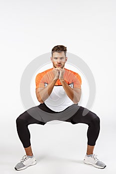 Full-length focused handsome young sportsman in activewear, spread feet sideways, perform fitness workout exercise, do